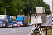 mobile speed camera device working on summer daytime road with blurry traffic in background