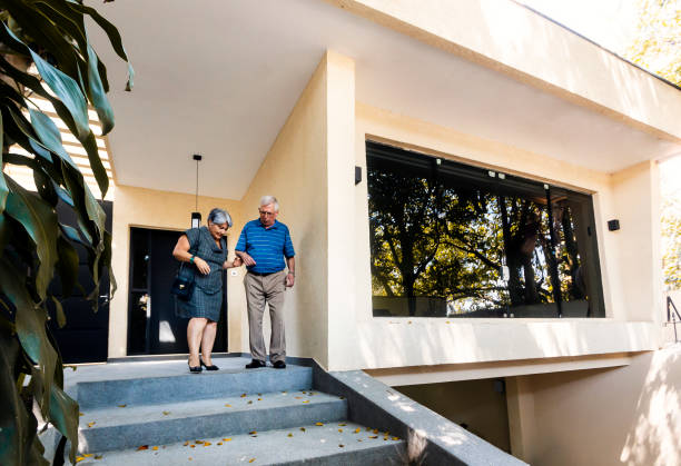 istock Elderly couple walking down the stairs at the front gate home 1184025725