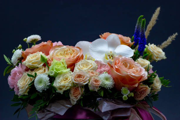 istock Mixed bouquet of different flowers in a hat box on a dark background 1184028304