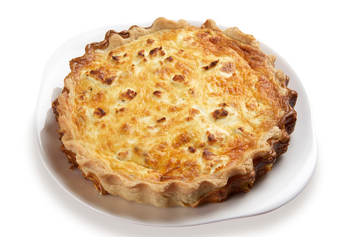 Leek and goats cheese quiche, whole on a white plate