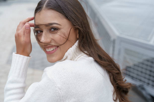 istock Pretty woman smiling when wind blowing on her hair 1184032796