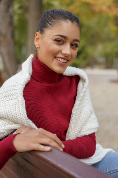 istock Cheerful lady sitting in the park alone 1184033582