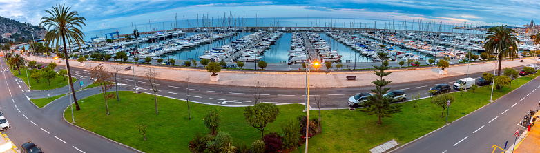 Scenic panoramic view of the harbor with yachts, city promenade and rainbow. Menton. France. Cote d'Azur.
