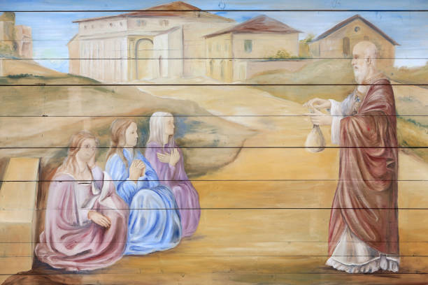 France. Haute-Savoie. Combloux. St. Nicholas Church. July, 7, 2016. This colorful image depicts the life of St. Nicholas, bishop of Myre, in restored mural painting by Edouard Borga, under the awning of St. Nicolas Church in Cordon. St. Nicolas St Nicolas has three poor girls. The church was rebuilt in 1702 on the site of the first church dating from the fifteenth century. It is dedicated to Saint Nicolas, whose legend is under the awning, patron of merchants, sailors and children.