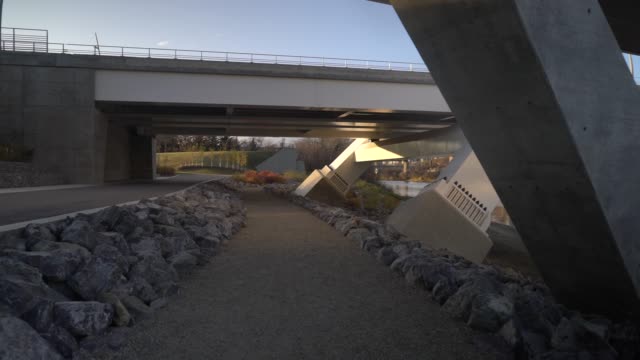 Establishing shot of a footpath under a bridge