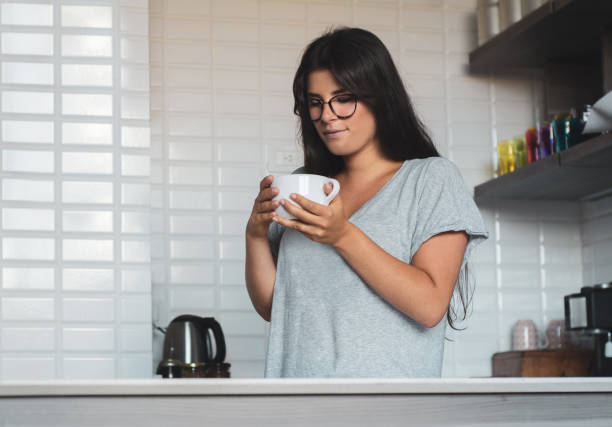istock young woman drinking coffee at home 1184039567