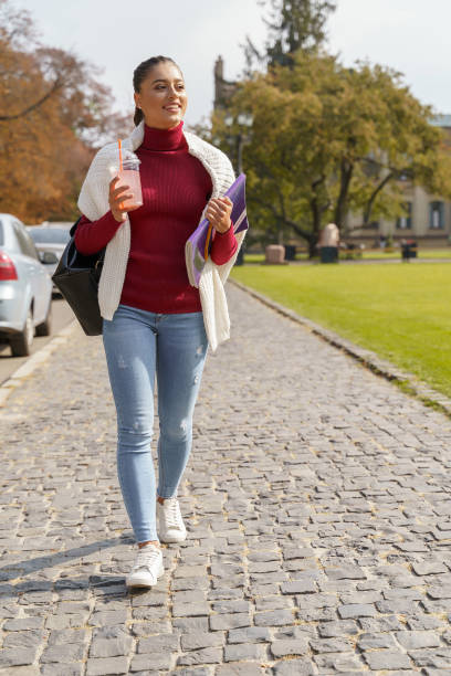 istock Cheerful student going home after her lessons 1184039769
