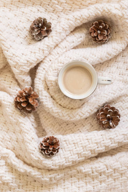 istock Cozy winter coffee composition with white sweater and pine cones. Flat lay, top view 1184040812