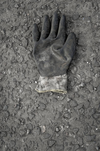 istock Abandoned work glove lying on the asphalt surface of a car park 1184040917