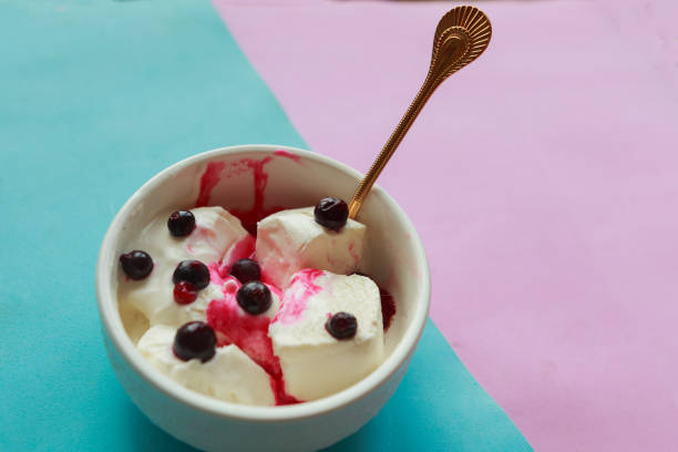 istock Vanilla ice cream with black berries in white bowl 1184041985