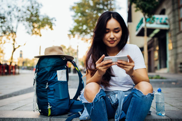 istock Cool girl on a journey using a smartphone 1184042142