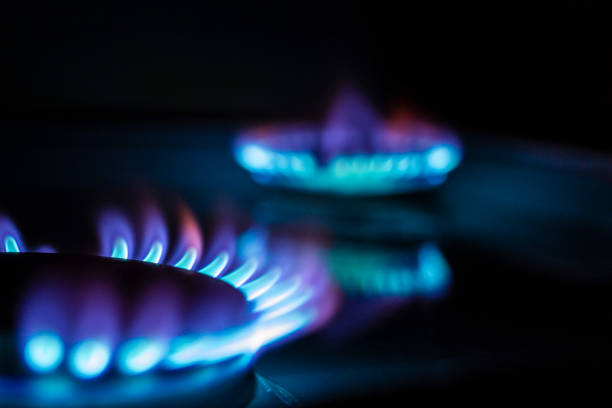 istock a hundred dollar bill on a gas burner with a burning fire on a black background, the front and back background is blurred with a bokeh effect 1184042272