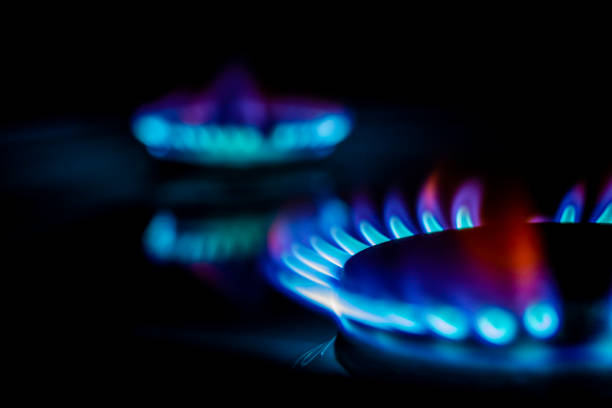 istock a hundred dollar bill on a gas burner with a burning fire on a black background, the front and back background is blurred with a bokeh effect 1184042279