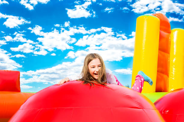 istock Happy Girl Child on Inflate Castle Cloudscape 1184043055