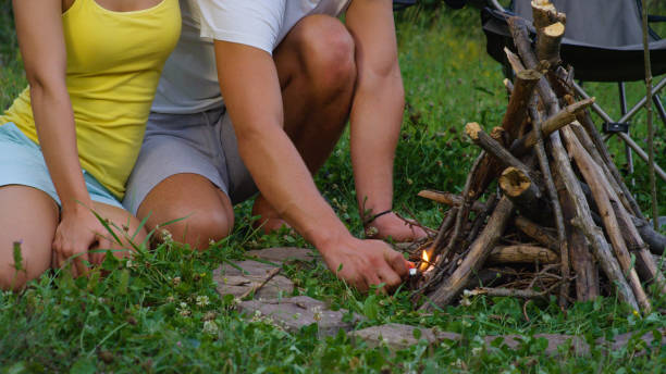 istock CLOSE UP: Unrecognizable man lights up a campfire while girlfriend sits by him. 1184048500