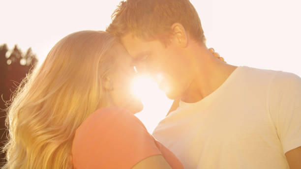istock LENS FLARE: Young lovers touching foreheads before kissing over the sunset. 1184048631
