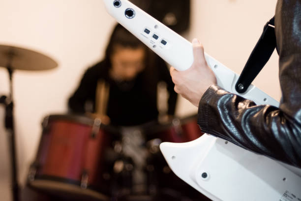 Young man playing keytar instrument in the studio
