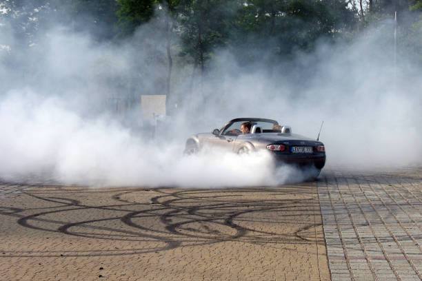 Street burnouts in a car Otwock, Poland - 26th May, 2008: Street burnouts in the Mazda MX-5 on the parking. This car was driven by licensed rally driver on the special public show. car burnout stock pictures, royalty-free photos & images