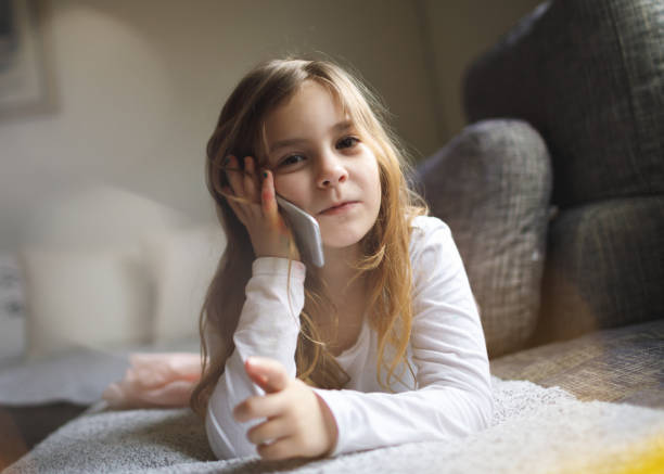 istock Young girl lying on bed and talking on phone 1184050712
