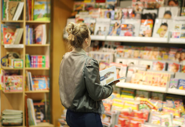 상점에서 마가진을 구입하는 여자 - carrying reading examining holding 뉴스 사진 이미지