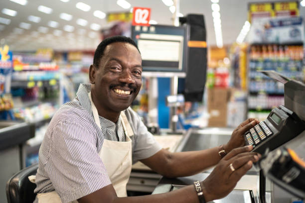 porträt des lächelnden kassierers supermarktmitarbeiter - markt verkaufsstätte fotos stock-fotos und bilder