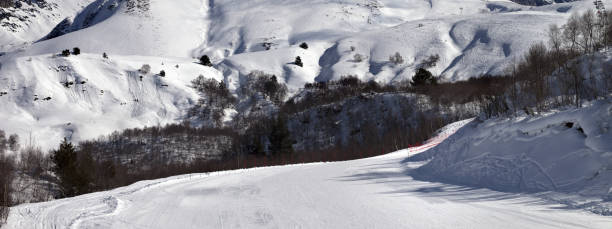 istock Ski slope and mountains in clouds at sunny day 1184062661