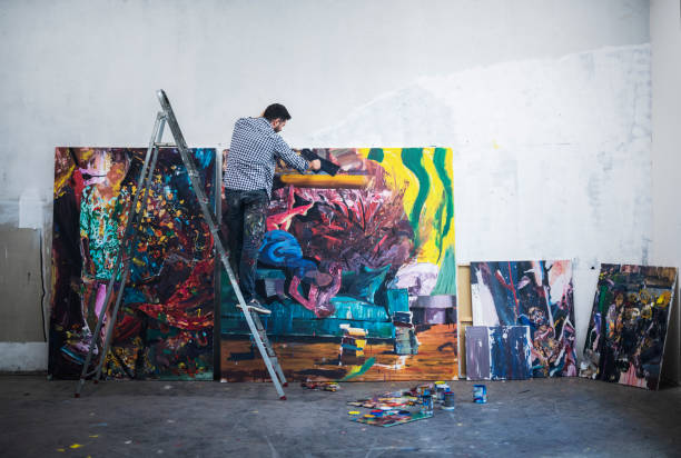 istock Young Artist working on big painting 1184062698