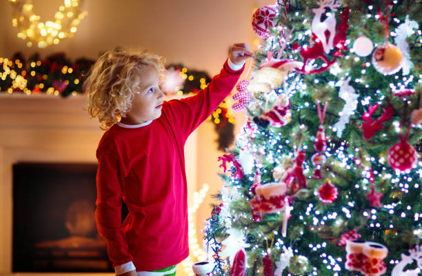 istock Child decorating Christmas tree. Kid on Xmas eve. 1184065817