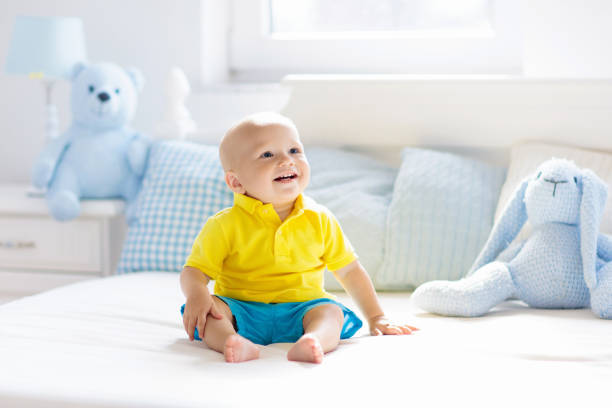 istock Baby boy playing on bed in sunny nursery 1184066265