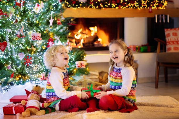 istock Child at Christmas tree. Kids at fireplace on Xmas 1184066363