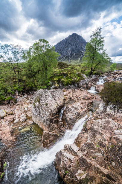 istock Glen Coe, Scotland, river with mountains and cloud in background 1184066542
