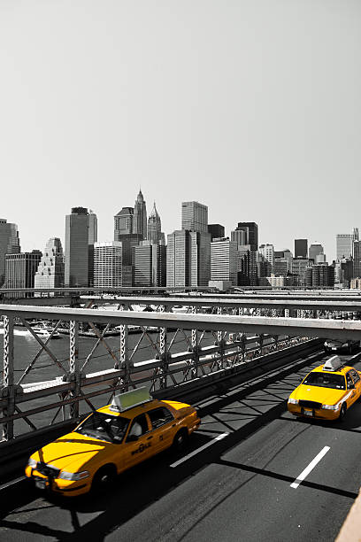 Yellow taxi cabs on Brooklyn bridge with Manhattan in background by day\n[url=/search/lightbox/7017035][IMG]http://farm3.static.flickr.com/2540/4008616250_4108b7faba.jpg[/IMG][/url]
