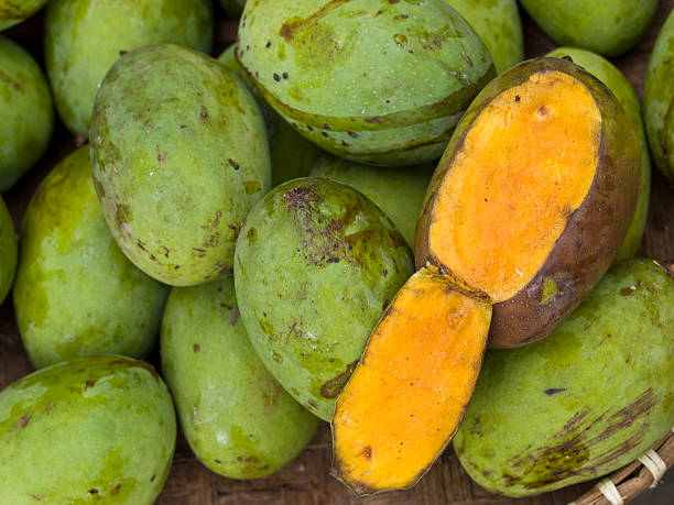 istock One peeled off mango in a stack of unpeeled ones 118408089