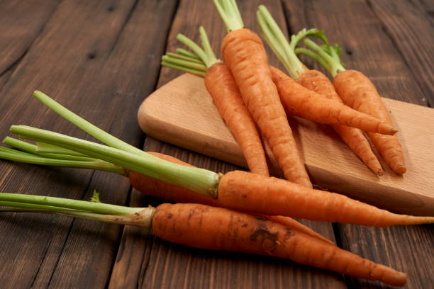 istock Carrots isolated on wood background 1184082964