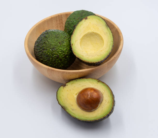 istock Avocado fruit in a wooden bowl on white background 1184087712