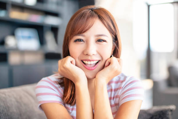 istock smiling young woman sitting on the sofa 1184090339