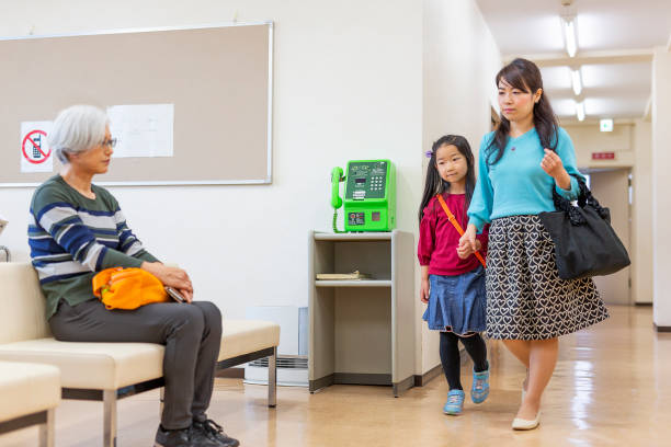 istock Mother and Daughter Walking Through a Hospital 1184102951