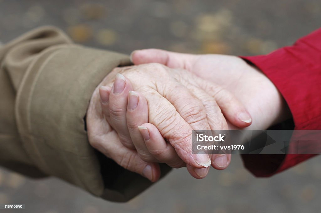 Primo piano di un nonno con suo grande figlia mano - Foto stock royalty-free di Adulto