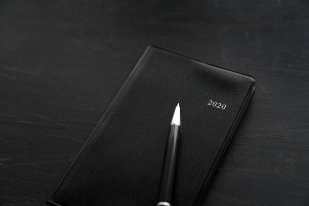 istock 2020 Notebook and pen on wooden background 1184110997