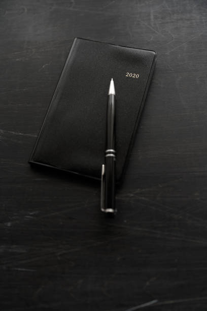 istock 2020 Notebook and pen on wooden background 1184111036