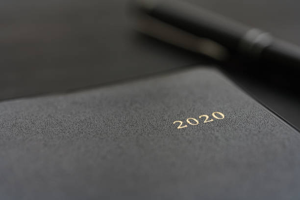 istock 2020 Notebook and pen on wooden background 1184111080