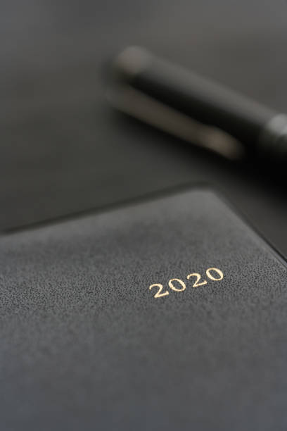 istock 2020 Notebook and pen on wooden background 1184111088