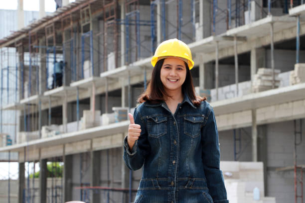 Female civil engineer or architect with yellow helmet, standing and thumbs up. stock photo