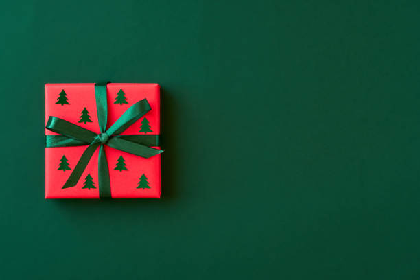 istock Red gift box on green background. Christmas card. Flat lay. Top view with space for text 1184132571