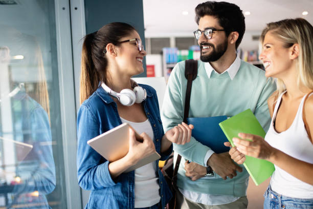 istock Happy young university students friends studying with books at university 1184133553