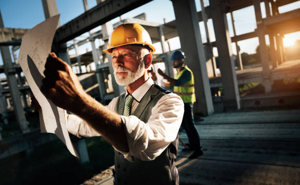 istock Confident construction engineer, architect, businessman in hardhat working on building site 1184133900