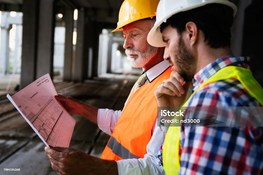 Mannelijke architecten analyseren blauwdruk op bouwplaats - Royalty-free Architect Stockfoto Mannelijke architecten analyseren blauwdruk op bouwplaats - Royalty-free Architect Stockfoto