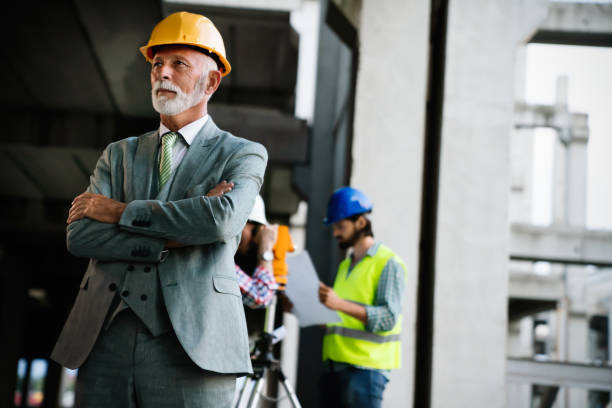 istock Confident construction engineer, architect, businessman in hardhat working on building site 1184134337