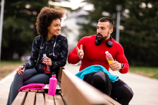 istock Two young athletes chatting and hydrating themselves while taking a break after exercising in a city park 1184137770