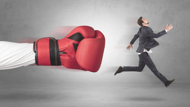 istock Businessman gets a hit from a giant hand 1184138030